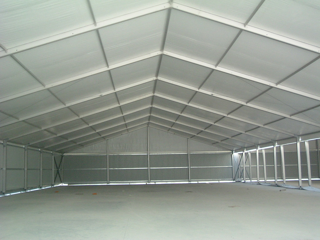 Interior of a large white warehouse tent with clear-span space